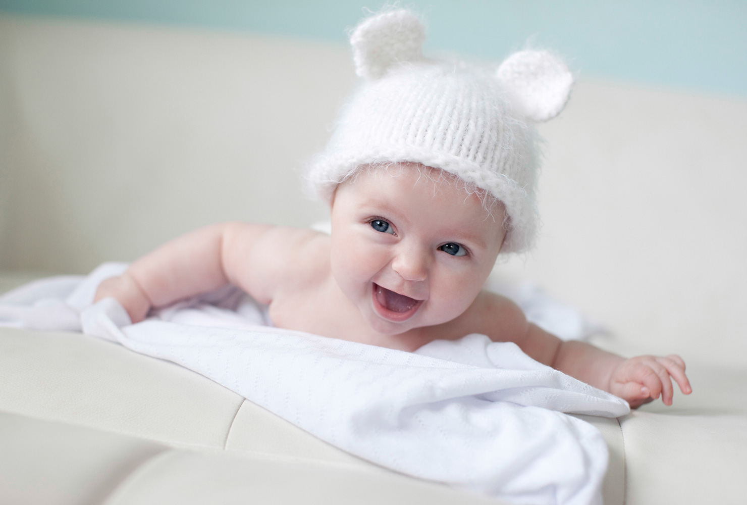 caucasian baby laughing with white hat