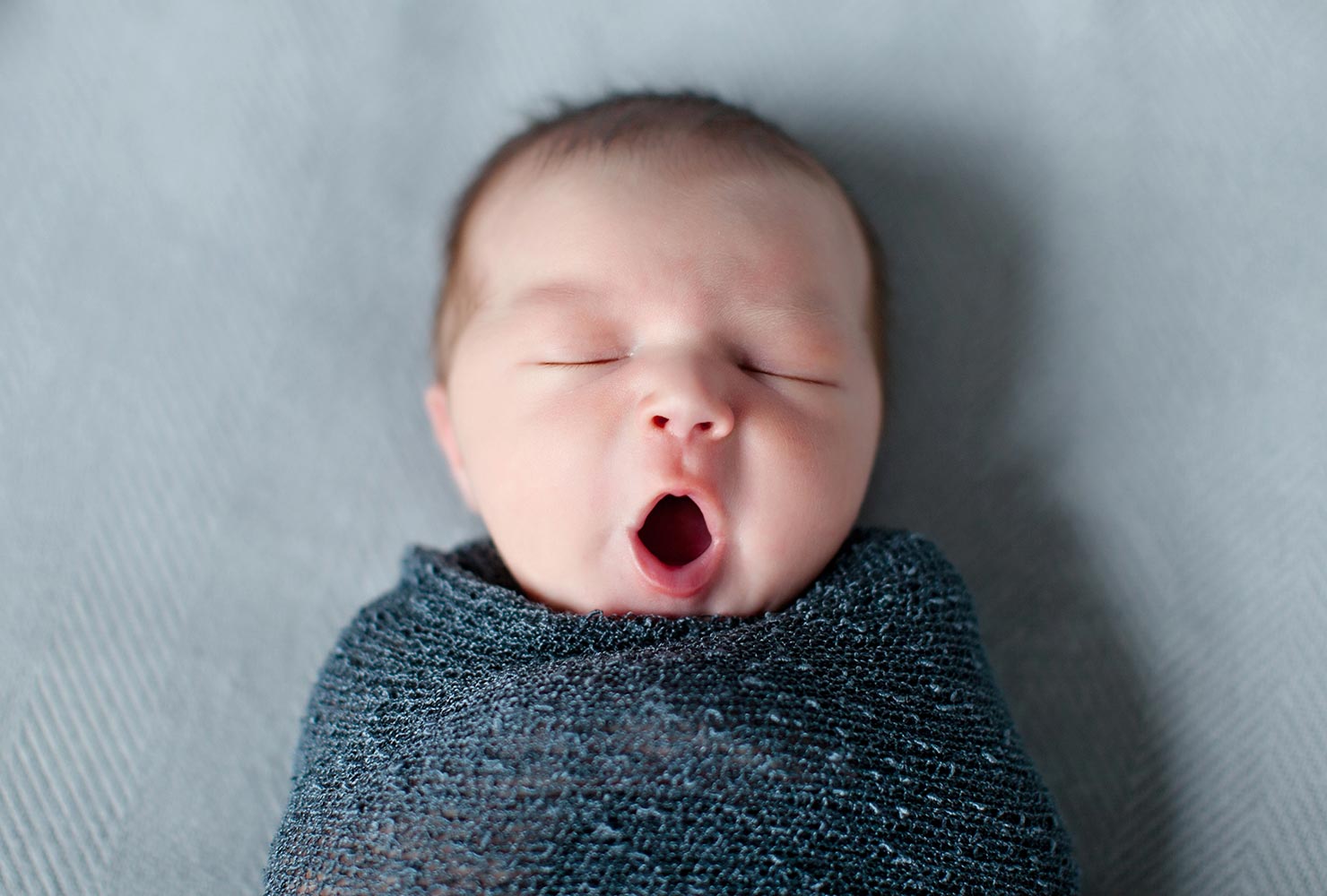 caucasian baby yawning in crib